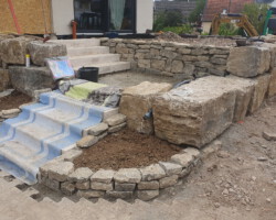 Terrasse mit Treppenstufen aus Muschelkalksteinen und Blöcken gebaut.