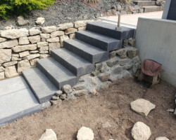 Blockstufen gesetzt und eine Natursteinmauer gebaut.