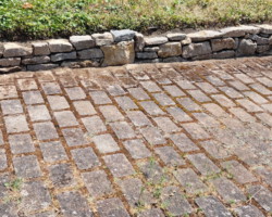 Kleine Natursteinmauer in der Hofeinfahrt